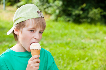 little boy eating ice cream in the park outdoors