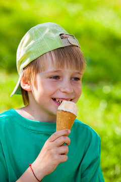 little boy eating ice cream in the park outdoors
