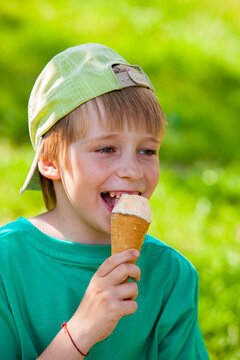 little boy eating ice cream in the park outdoors