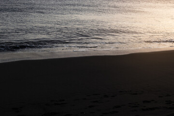 Black sand beach with sunset light