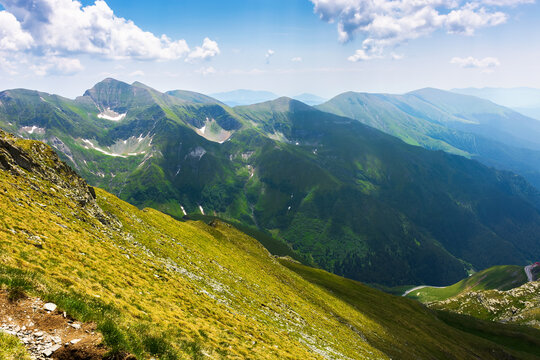 landscape of fagaras mountains in summer. beautiful nature scenery of romania. steep hills, grassy meadows and rocky peaks on a sunny day. popular travel destination