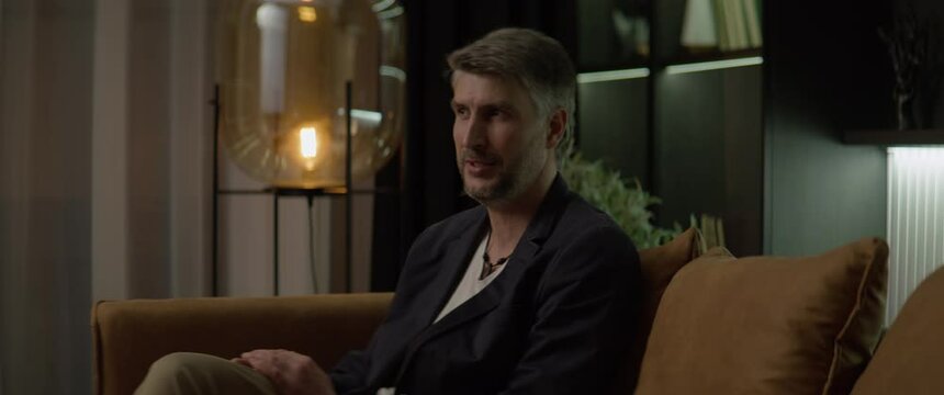CU Portrait of 40s Caucasian male having an appointment with his psychologist in the evening. Shot with 2x anamorphic lens