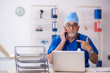 Old male doctor working in the clinic