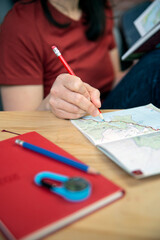 Person planning a trip with a map and a guidebook