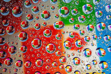 Water droplets on a glass in form of lenses with a colourful background. Wallpaper for screen. Abstract background.