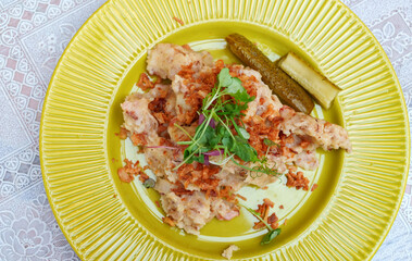 Mashed potatoes with cracklings in a yellow plate.