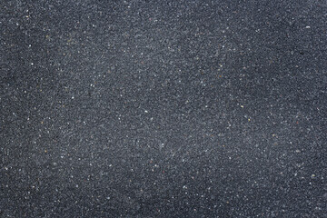 Smooth dark gray asphalt pavement texture with small stones