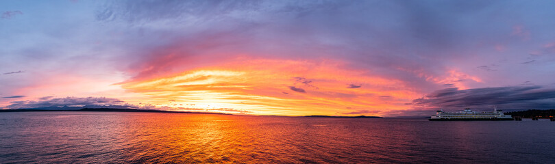 A view of the Olympic Mountains in the background and Puget Sound in the foreground at sunset with...
