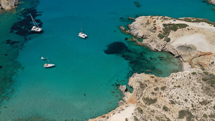 Aerial drone photo of tropical exotic paradise bay with deep turquoise sea forming a blue lagoon visited by luxury yachts and sail boats