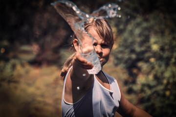 Naklejka premium The child splashes water from a glass in a rage . A young girl screams and swears. Child aggression . Water splashes in close - up .