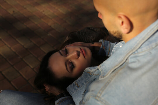  Top view of a girl's head lying on the knees of a guy with his eyes closed