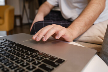 A man works at a laptop at the table. Remote work from home. Businessman at work in the office. Business background. Home office
