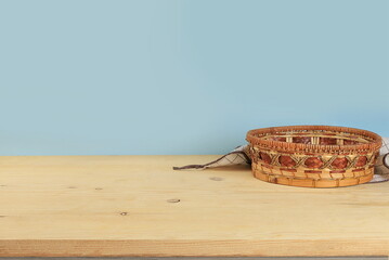 Empty wooden table with wicker basket on old background with space for text, rustic style, eco...