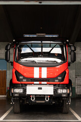 Full length view of the big red fire engine standing at the garage. Red fire engine, emergency rescue truck with flasher siren light