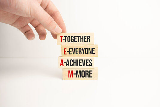 TEAM, together everyone achieves more symbol. Wooden cubes with words