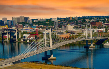 An aerial view at sunrise of the Tilikum Cable-stayed bridge in downtown Portland, Oregon.  It is used for bicycles, walking, light rail and bus traffic.