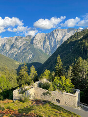 VERTICAL: Ancient WW1 outpost overlooks the golden lit mountains of Slovenia.