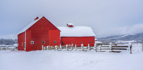 A red barn, fence and pasture covered with snow near Jefferson Oregon