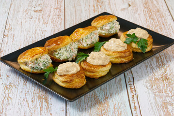 puff pastry-filled appetizer with salad filling on a plate. close up