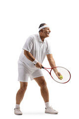 Full length profile shot of a mature man playing tennis and starting a serveFull length profile shot of a mature man playing tennis and starting a serve