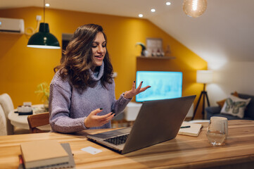 Hispanic woman using a laptop while working form home