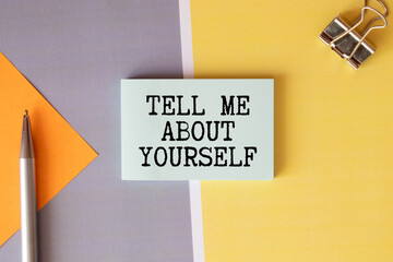 text TELL ME ABOUT YOURSELF on white noteboock. - obrazy, fototapety, plakaty