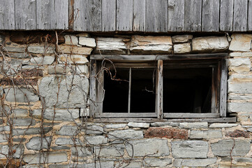 old wooden window on stone wall of barn
