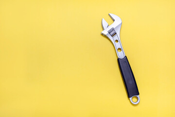 Modern pipe wrench on a yellow background with free space for text. The concept of a tool for repair or construction. Special tool for repairing pipes and clamping nuts