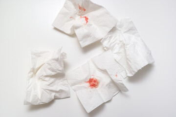 Blood on used toilet paper on white background, anal bleeding and hemorroidis concept
