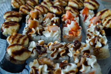 different sushi and rolls. baked sushi with various sauces. tasty food.