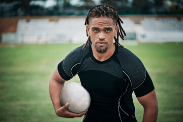 I'm ready to score some points. Cropped portrait of a handsome young rugby player holding a rugby ball while standing on the field.