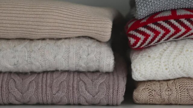 Closeup video of neatly folded clothes in wardrobe