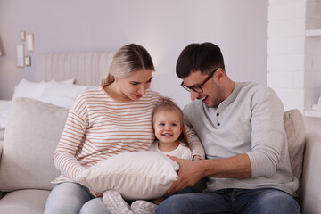 Fototapeta premium Family with little daughter spending time together on sofa at home