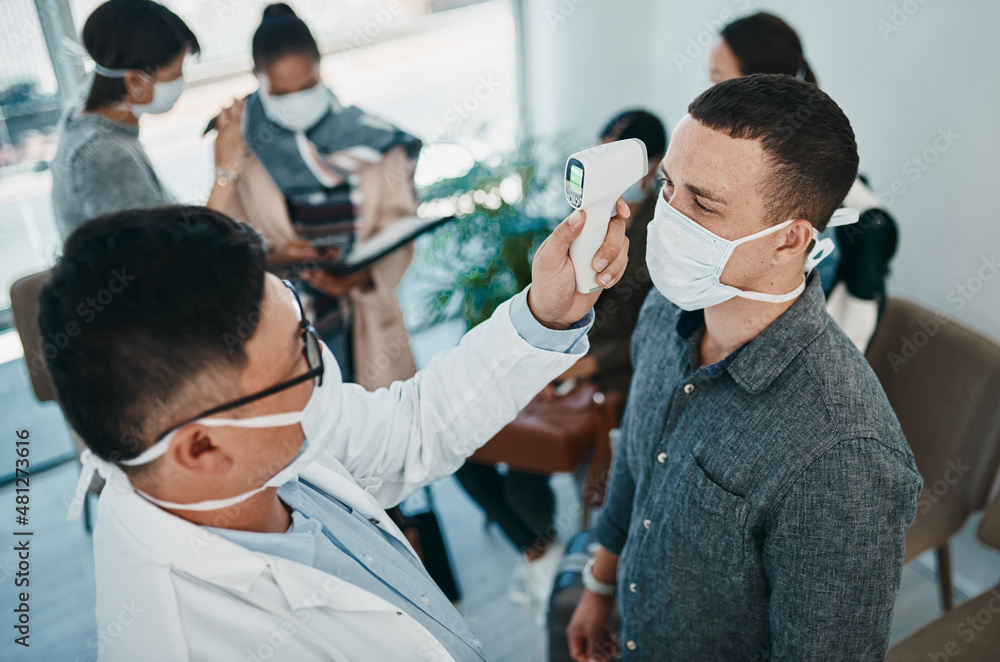 Poster it all starts with a fever. shot of a young man getting his temperature taken with an infrared therm
