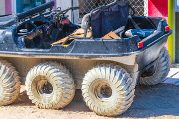 Buggy golf cart 6 wheels muddy street village Holbox Mexico.