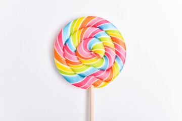 A colored lollipop on a stick. Sweet dessert. Confectionery background. Copy space. Flat lay, top view
