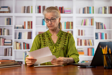 Excited woman reading mail letter of great news. Amazed female professional winner feeling happy...