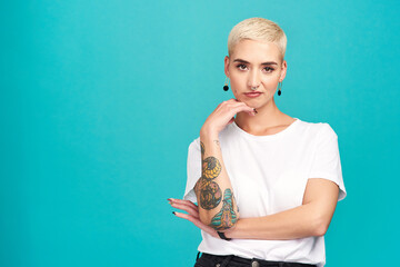 My style, my choice. Studio shot of an attractive young woman posing against a turquoise background.