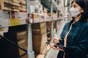 Fototapeta premium Woman worker using digital tablet checking the stock inventory, Smart warehouse management system, Supply chain and logistic network technology concept.