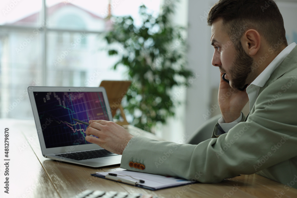Poster forex trader talking on phone while working in office