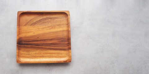Empty wooden plate on gray cement table background, banner with copy space, Blank wood tray for food display montage, template, mock up, top view, flat lay