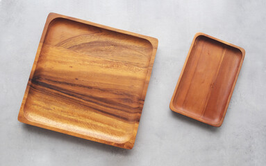 Empty wooden plate on gray cement table background, banner with copy space, Blank wood tray for food display montage, template, mock up, top view, flat lay