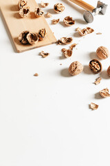Cosy autumn aesthetic composition with dry  leaves, walnuts on white background. Flat lay, top view, copy space.