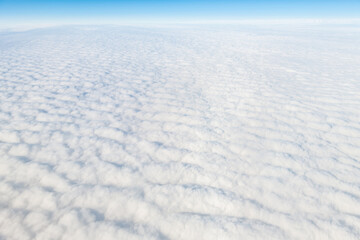 Reykjavik, Iceland flying above island with cloudscape aerial high angle view above of cloudy landscape horizon with blue sky and pattern of white fluffy clouds from airplane