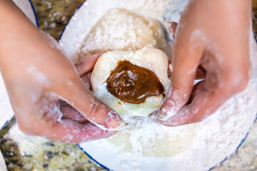 Flat top view of hands shaping cooking making mochi sticky daifuku Japanese rice cake with...