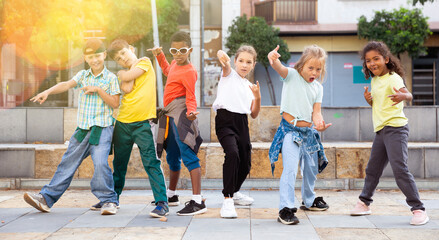 Modern tweens dancing on summer street. Urban lifestyle. Hip-hop generation