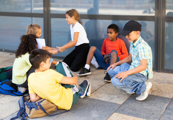 Group of schoolchildren with backpacks having fun at break time