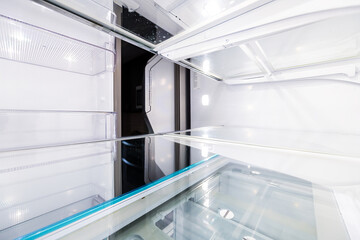 Interior of empty modern French door fridge refrigerator with camera point of view from inside pov with clean shelf shelves closeup