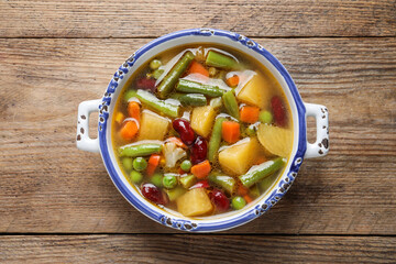 Bowl of tasty turnip soup on wooden table, top view