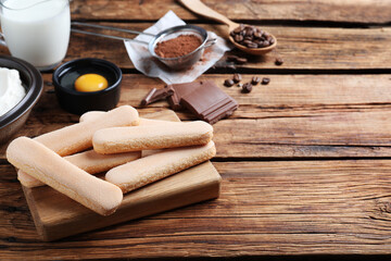 Tasty cookies and other tiramisu ingredients on wooden table, space for text